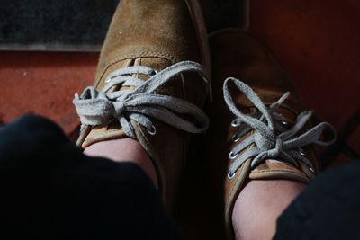 Low section of woman wearing shoes standing on floor