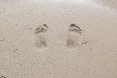 High angle view of footprints on sand at beach