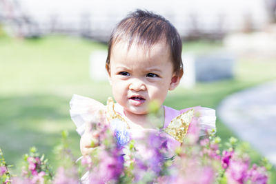 Portrait of cute baby girl on flowering plant