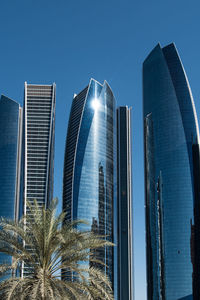 Low angle view of modern buildings against clear blue sky