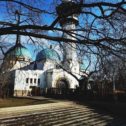 Low angle view of bare trees and buildings against sky