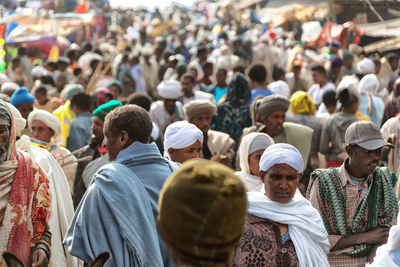 Rear view of people standing on street in city