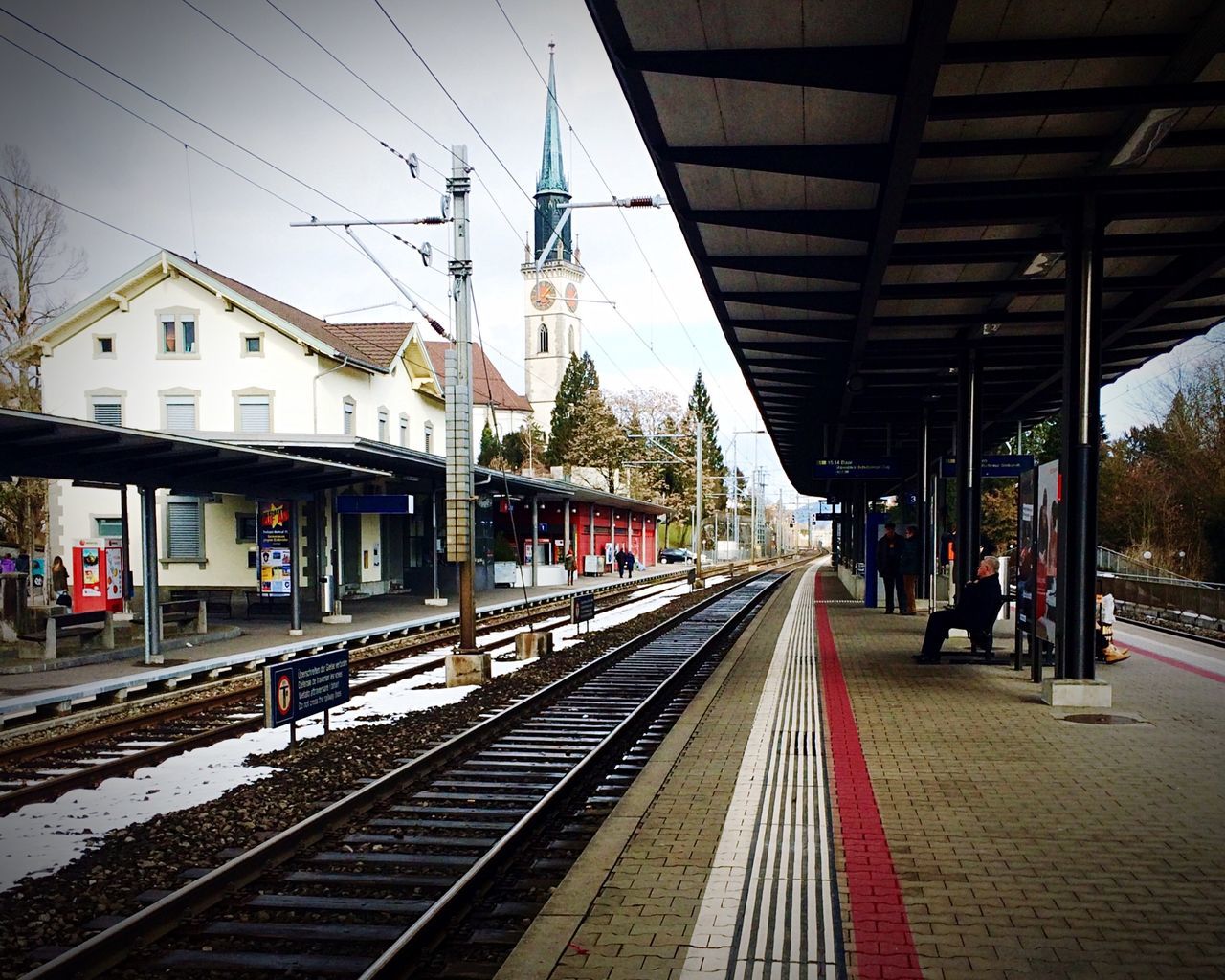 railroad track, rail transportation, railroad station platform, railroad station, public transportation, transportation, built structure, architecture, train - vehicle, the way forward, building exterior, railway track, diminishing perspective, railway station, incidental people, travel, public transport, city, passenger train, vanishing point