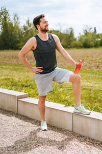 Full length of young man with arms raised