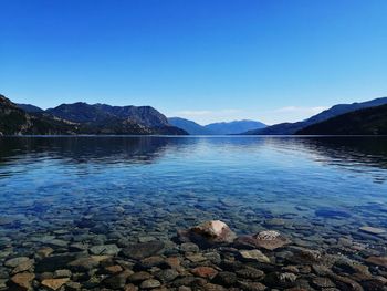 Scenic view of lake against clear blue sky