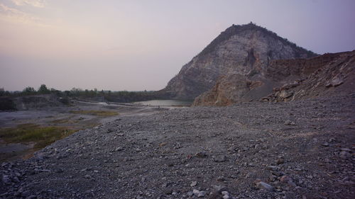 Rock formations on landscape against sky during sunset