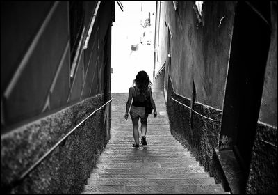 Rear view of woman walking down stairs