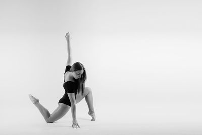 Full length of woman exercising against clear sky