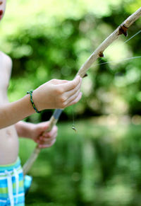 Midsection of shirtless man holding fishing net