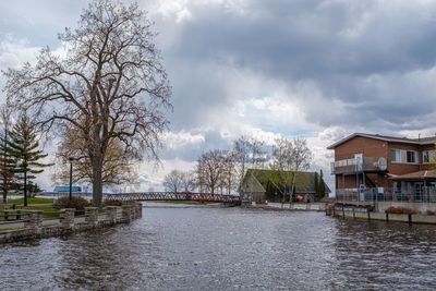 River amidst houses and buildings against sky