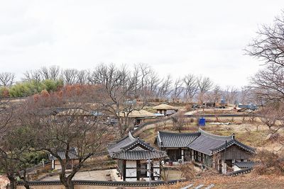 High angle view of houses and trees on field against sky