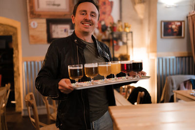 Portrait of a young man with drink in restaurant