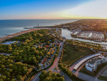 High angle view of cityscape by sea against sky