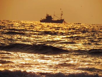 Close-up of man touching sea at sunset