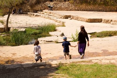 Rear view of people walking on footpath