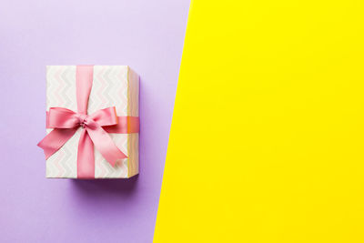 Close-up of gift against yellow background