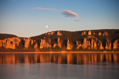 Scenic view of full moon and rock formations relfected in calm lake