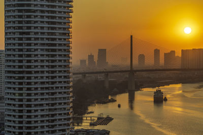 Modern buildings against sky during sunset