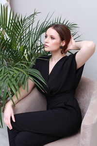 Portrait of young woman sitting on bed