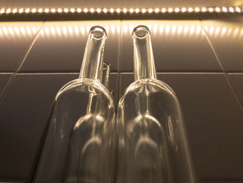 Low angle view of bottles against illuminated wall