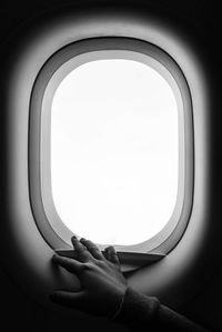 Cropped image of person hand on airplane window