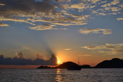 Silhouette sailboats in sea against sky during sunset