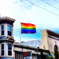 Low angle view of rainbow over buildings against sky