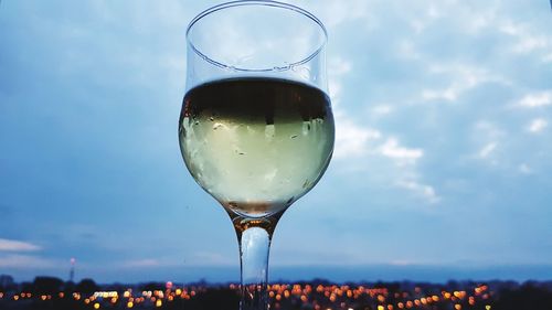 Close-up of wineglass against sky