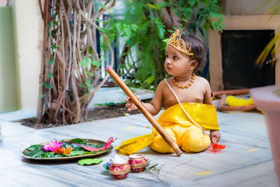 Adorable infant dressed as hindu god krishna cute facial expression with flute at janmashtami