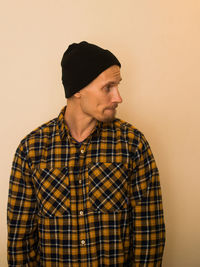 Young man looking away against white background
