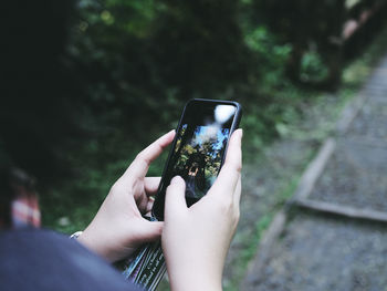 Midsection of person holding smart phone