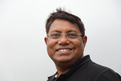 Portrait of smiling young man against white background