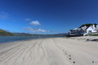 Scenic view of beach against blue sky