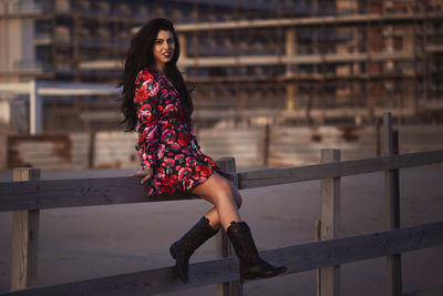 Portrait of smiling woman against railing