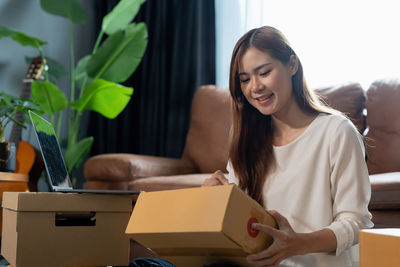 Young woman using digital tablet while sitting at home