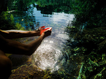 Low section of person relaxing in lake