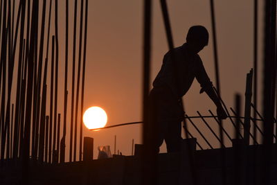 Silhouette man working at sunset