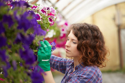 Portrait of woman holding purple flowering plant