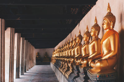 Golden meditation buddha image statues around  temple of wat phutthaisawan at ayutthaya, thailand. 