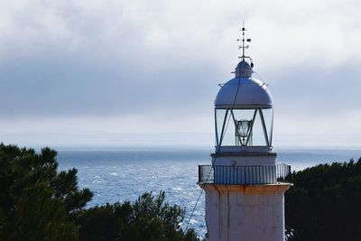 High section of lighthouse against cloudy sky
