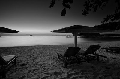 Lifeguard hut on beach against sky during sunset