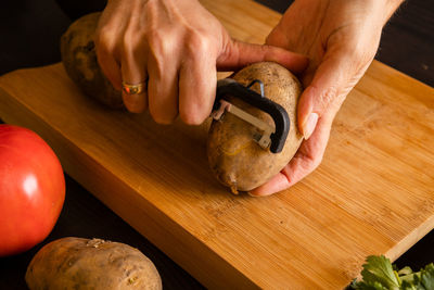 Cropped hands of man preparing food on cutting board