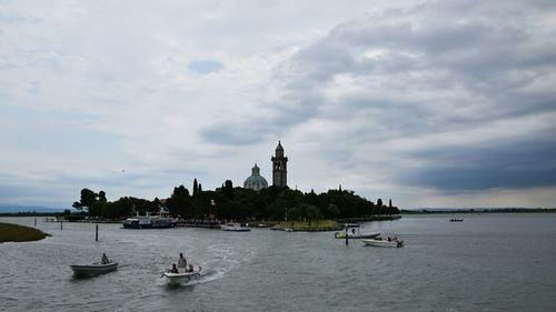 View of boats in sea against cloudy sky