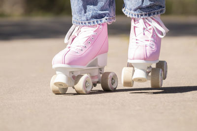 Closeup of some pink roller skates skating down the street