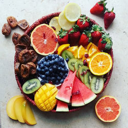 Close-up of tropical fruits in red tray on stone table 