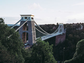 View of bridge in city against cloudy sky