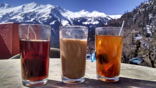 Close-up of beer glasses against mountains