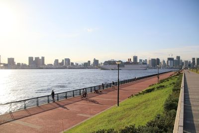 City by river and buildings against sky