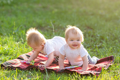 Sisters playing with toys while sitting at lawn
