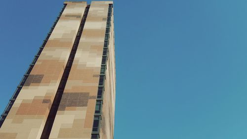 Low angle view of skyscraper against clear blue sky